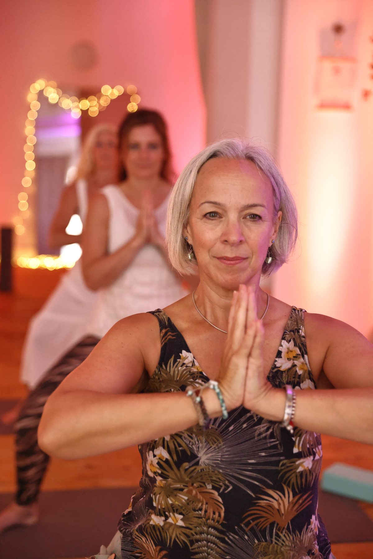 A guided yoga session in progress, in prayer pose
